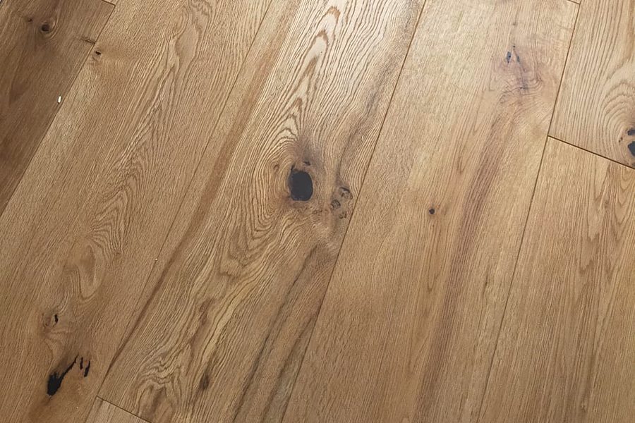 Pavimento in legno a doghe larghe appena posato, con nodi e venatura in vista